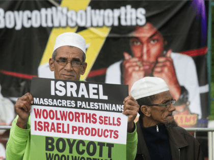 A Muslim man holds a placard reading 'Israel massacres Palestinians. Woolworths sells Israeli products', during a protest against Grammy-winning American musician Pharrell Williams near the Grand west Casino where he was holding a concert in Cape Town, on 21 September, 2015.