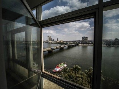A picture taken through the window of a building shows the Nile river and Cairo's sky