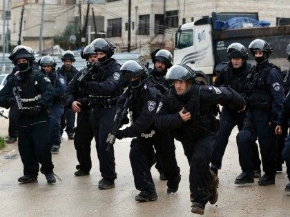 Israeli policemen secure an area where a house belonging to a Palestinian family is demolished by Israeli authorities that they said was built without a municipality permit, in the Arab east Jerusalem neighbourhood of Shuafat on January 27, 2016.