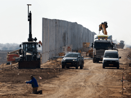 Israeli workers erect a new fence along Israel's border with Jordan in the Arabah val