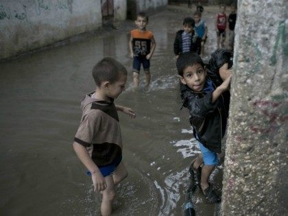Palestinian boys stand on a flooded street after heavy rain in Khan Yunis in the southern Gaza Strip on October 7, 2015.