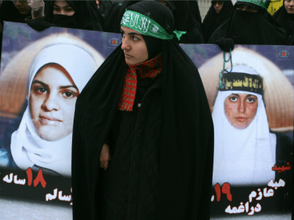 An Iranian woman stands between portraits of Palestinian female suicide bombers during a protest against Israel's blockade of the Gaza Strip, in front of the United Nation's office in Tehran, 24 January 2008.