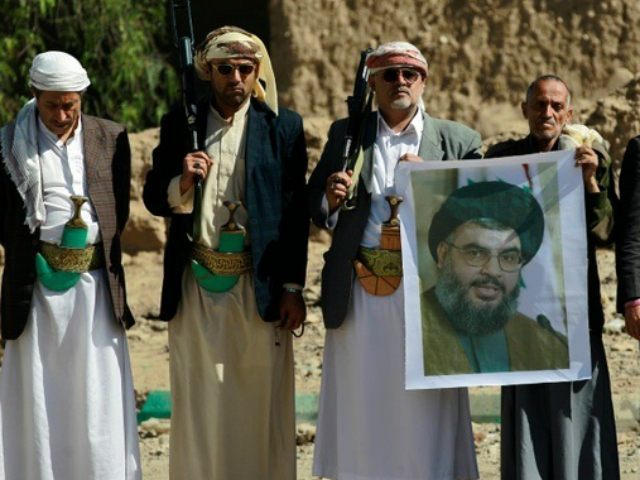 Huthi militiamen hold posters depicting Lebanon's Hezbollah chief Hassan Nasrallah during