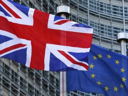 A Union Jack flag flutters next to European Union flags …