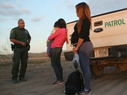 An immigrant from El Salvador, seven months pregnant, she said, stands next to a U.S. Border Patrol truck after she and others turned themselves in to border agents on December 7, 2015 near Rio Grande City, Texas.