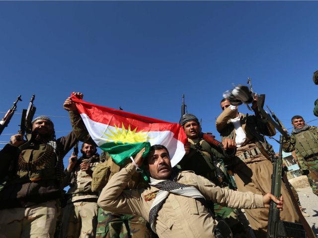 IRAQ, SINJAR : Iraqi autonomous Kurdish region's peshmerga forces and fighters from the Yazidi minority, a local Kurdish-speaking community which the Islamic State (IS) group had brutally targeted in the area, raise the Kurdish flag in northern Iraqi town of Sinjar, in the Nineveh Province, on November 13, 2015. Iraqi …