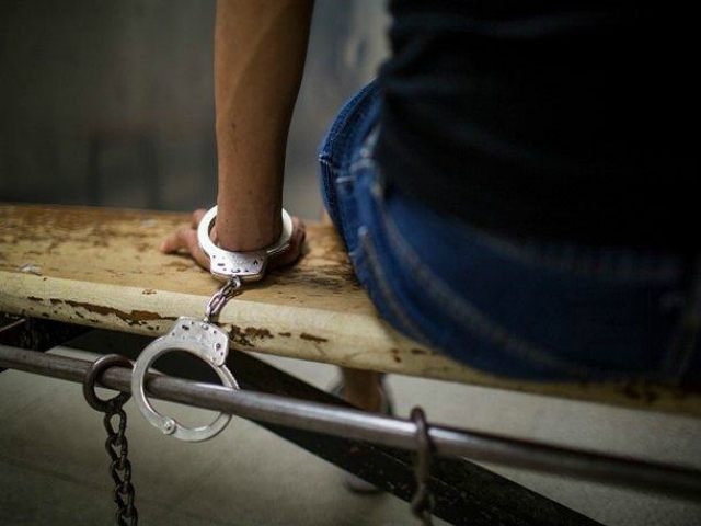 View of an unidentified male suspect handcuffed to a bench in the Southeast Community Police Station, Los Angeles, California, April 24, 2015. The man had been arrested for solicitation of prostitution in the South Figueroa Street corridor by the LAPD's Human Trafficking Task Force. (Photo by Robert Nickelsberg/Getty Images)