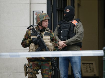 A police officer and a soldier stand guard outside the Council Chamber of Brussels on March 24, 2016 during investigations into the Paris and Brussels terror attacks.