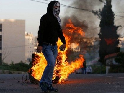 A Palestinian protester holds stones during clashes with Israeli security forces on March 11, 2016, following a demonstration in solidarity with Palestinian prisoners held in Israeli jails, outside the compound of the Israeli-run Ofer prison near Betunia in the occupied West Bank.