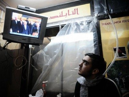 A Palestinian man watches the live televised inauguration ceremony for US President Barack