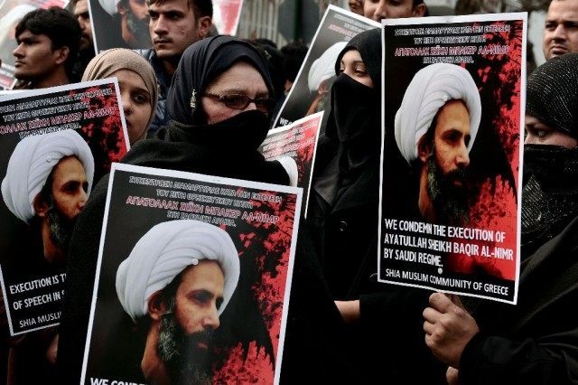 TOPSHOT - Members of the Shia Muslim community of Greece hold up placards and banners bear