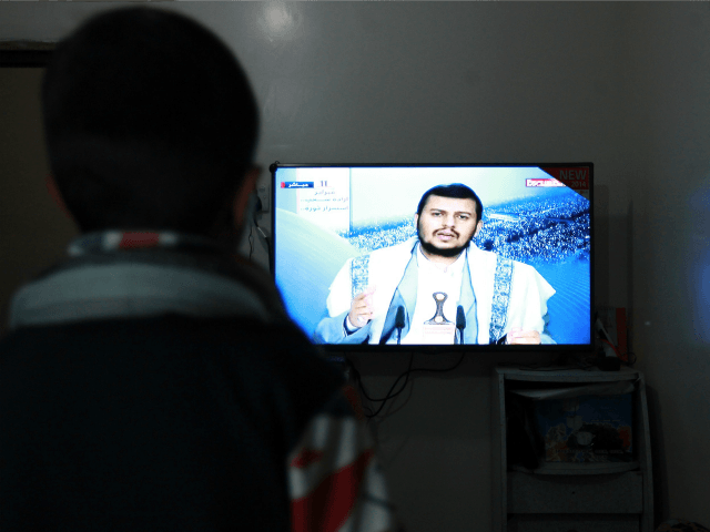 A Yemeni man watches the televised speech of the Shiite Huthi movement's leader Abdul