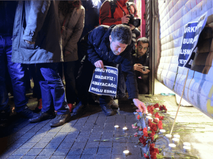 A man lights a candle at the site of a blast on Istiklal Street, a major shopping and tour