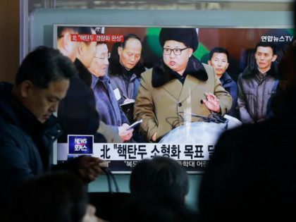 South Korea -- People watch a TV news program showing North Korean leader Kim Jong Un with