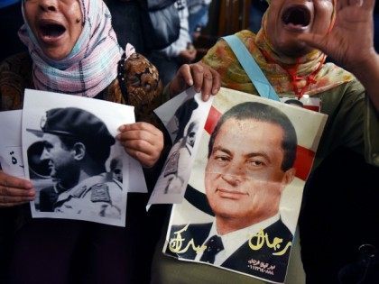 Supporters of Egypt's former president Hosni Mubark (portraits) shout slogans praisin