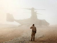 A U.S. Marine watches as an Osprey carrying U.S. Defense Secretary Leon Panetta arrives at Forward Operating Base Shukvani, Afghanistan March 14, 2012. REUTERS/SCOTT OLSON/POOL
