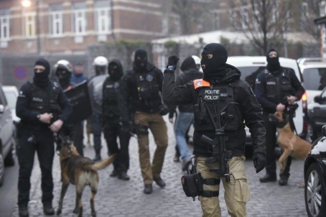 Belgian police walk in a street during a police action in the Molenbeek-Saint-Jean distric