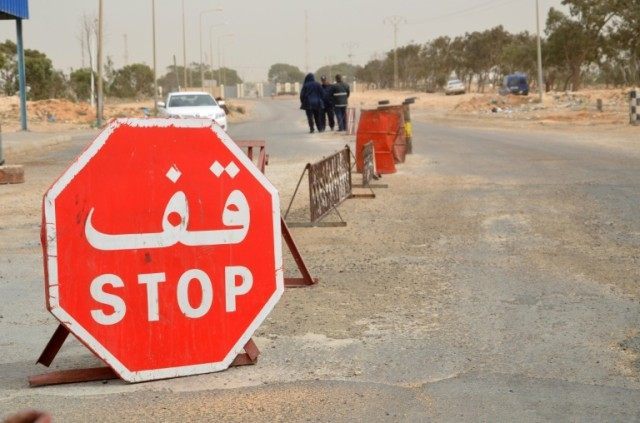 Tunisian security forces check vehicles near the customs post at the Ras Jedir border cros