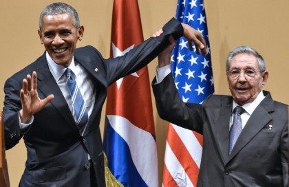 Cuban President Raul Castro (R) raises US President Barack Obama's hand during press conference at the Revolution Palace in Havana on March 21, 2016