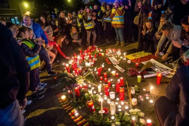 Brussels airport workers and their relatives pay tribute to the victims of triple attacks in Brussels, at a makeshift memorial near the airport in Zaventem on March 23, 2016