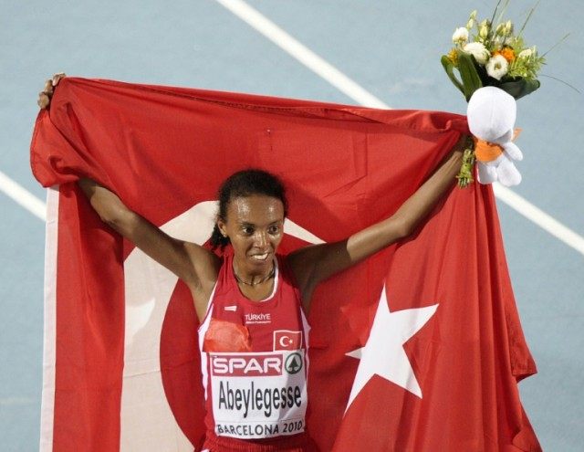 Turkey's Elvan Abeylegesse poses with a Turkish flag after winning the women's 10,000m fin