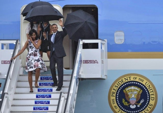 US President Barack Obama waves next to First Lady Michelle Obama as they arrive with thei