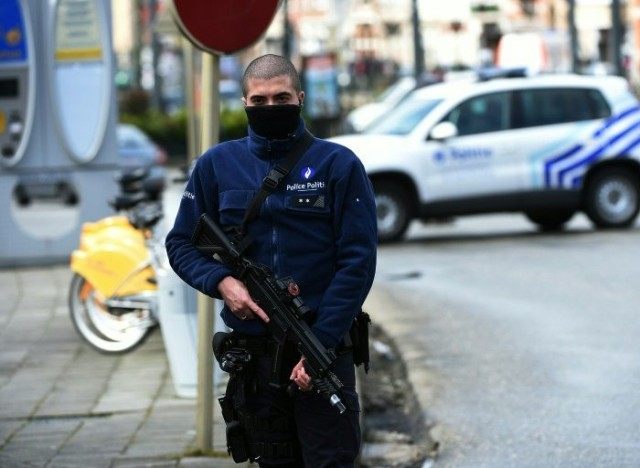 A Belgian police officer stands guard during an anti-terror raid in the Schaerbeek - Schaa