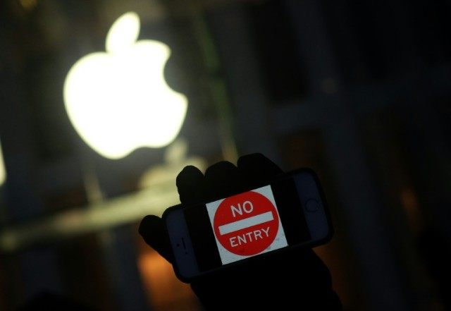 An anti-government protester holding his iPhone with a sign "No Entry" during a demonstrat
