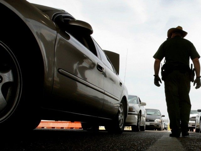 April 23, 2009 file photo, a U.S. Customs and Border Protection agent checks traffic in La