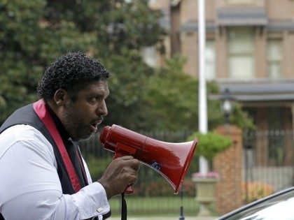 Rev. William Barber, President of the North Carolina branch of the NAACP, speaks to protestors as they march around the executive mansion to demonstrate against voting law changes by the state's Republican-led legislature. (AP Photo/Gerry Broome)