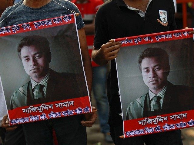 People carry portraits of student activist Nazimuddin Samad as they attend a rally to dema