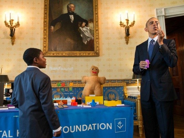 Jacob Leggette, 9, of Baltimore, Md., who creates toys using a 3D printer, watches as Pres