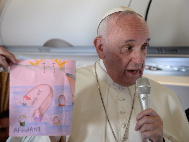 Pope Francis shows drawings made by children on his flight back to Rome following a visit to the Greek island of Lesbos, Saturday, April 16, 2016. Pope Francis gave Europe a provocative and concrete lesson in how to treat refugees Saturday by bringing home 12 Syrian Muslims aboard his charter …