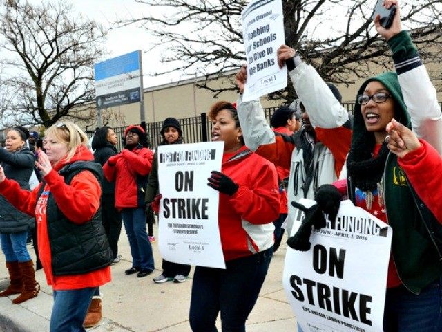 Chicago teachers and supporters carry picket signs outside Beasley Academic Center in Chic