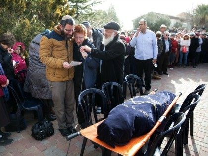 Natan, the husband of Dafna Meir and her son speak during her funeral ceremony in the Jewi