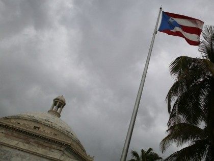 The Puerto Rican flag flies near the Capitol building as the island's residents deal