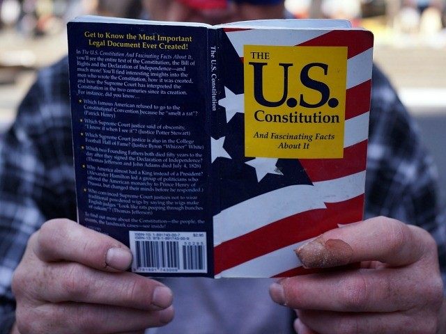 A man holding a copy of the U.S. Constitution on May 1, 2014 in New York City.