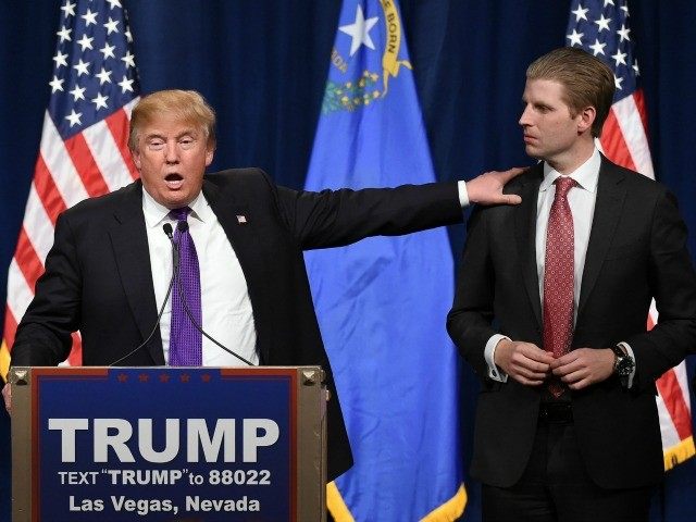 Republican presidential candidate Donald Trump (L) speaks as his son Eric Trump looks on d
