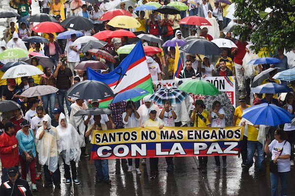 People hold a banner reading "Santos, no more deceit with peace" as they take part in the "No More" march against the government of President Juan Manuel Santos and the Revolutionary Armed Forces of Colombia (FARC) guerrillas in Cali, department of Valle del Cauca, Colombia, on April 2, 2016. The government of President Santos and the FARC have been holding peace talks for three years to end a half-century guerrilla war that has killed more than 260,000 people. AFP PHOTO / LUIS ROBAYO / AFP / LUIS ROBAYO (Photo credit should read LUIS ROBAYO/AFP/Getty Images)