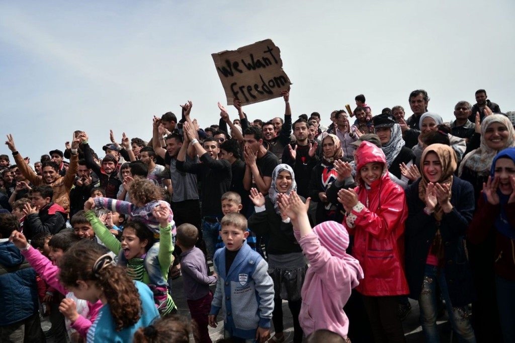 Syrian refugees protest chanting 'No Turkey, No Vial ( detention center)' at the port of Chios where refugees and migrants who broke out from Vial detention center camp out on April 3, 2016. Under a European Union deal with Turkey, migrants and refugees arriving after March 20 are to be held in centres set up on five Aegean islands, including Chios, and sent back if their asylum applications are not accepted. Returns are supposed to begin on April 4. / AFP / LOUISA GOULIAMAKI (Photo credit should read LOUISA GOULIAMAKI/AFP/Getty Images)