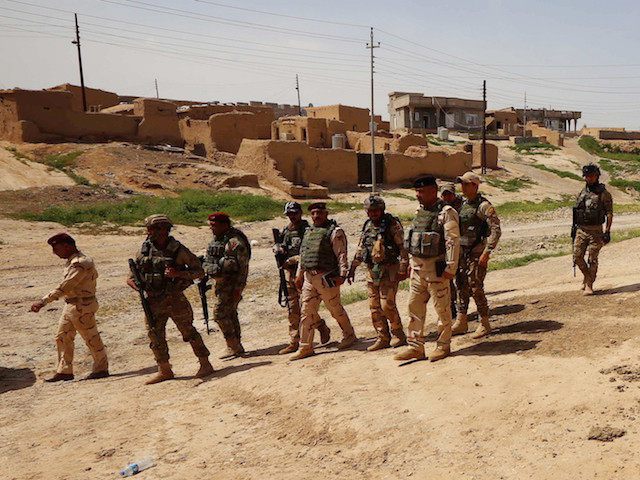Iraqi soldiers secure an area near the frontline on April 9, 2016 in the town of Kharbarda