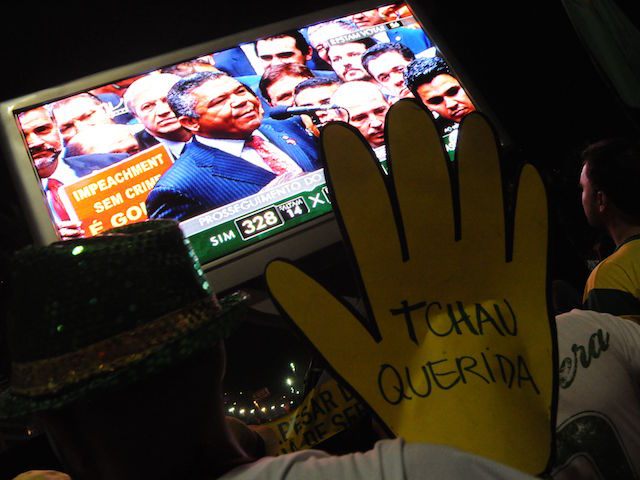 Supporters of the impeachment of Brazilian President Dilma Rousseff follow on big screens in Rio de Janeiro, Brazil, as lawmakers get close to be votes needed to authorize her impeachment to go ahead, on April 17, 2016. Brazilian lawmakers on Sunday reached the two thirds majority necessary to authorize impeachment proceedings against President Dilma Rousseff. The lower house vote sends Rousseff's case to the Senate, which can vote to open a trial. A two thirds majority in the upper house would eject her from office. Rousseff, whose approval rating has plunged to a dismal 10 percent, faces charges of embellishing public accounts to mask the budget deficit during her 2014 reelection. / AFP / TASSO MARCELO (Photo credit should read TASSO MARCELO/AFP/Getty Images)