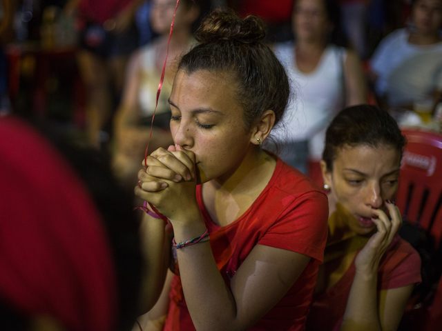 SAO PAULO, BRAZIL - APRIL 17: Protesters opposed to the impeachment of President Dilma Rousseff watch the voting session on television from within the central regions April 17, 2016 in Sao Paulo, Brazil. The Lower House of Congress will hold a vote on whether to impeach Rousseff over charges of manipulating government accounts for political gains. (Photo by Victor Moriyama/Getty Images)