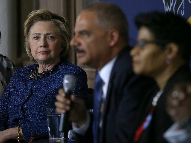 Democratic presidential candidate former Secretary of State Hillary Clinton (L) looks on as former attorney general Eric Holder speaks April 20, 2016 in Philadelphia.