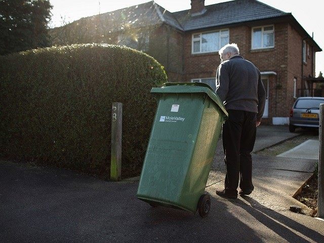 LEATHERHEAD, UNITED KINGDOM - MARCH 02: A local resident takes his emptied recycling bin