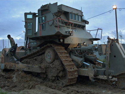 An Israeli soldier climbs down from a bulldozer after returning from the Gaza Strip February 13, 2002 at the Israeli controlled Erez crossing.