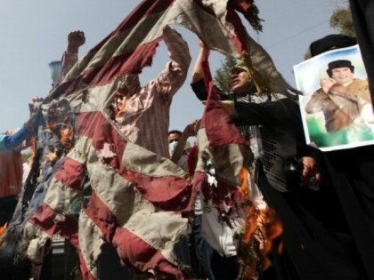 Supporters of Libyan leader Moamer Kadhafi burn a US flag as they protest outside his house which was hit by a NATO air strike overnight in the Gargur area of Tripoli on May 1, 2011 as the Libyan regime said the raid killed Kadhafi's youngest son and three grandchildren but …