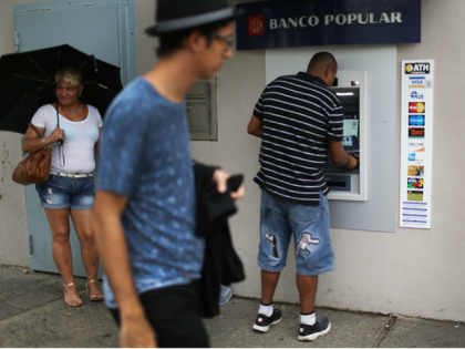 People use a Banco Popular ATM machine a day after Puerto Rican Governor Alejandro Garcia Padilla gave a televised speech regarding the governments $72 billion debt on June 30, 2015 in San Juan, Puerto Rico.