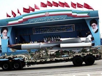 A S-200 surface-to-air missile system is driven past Iranian military commanders during th