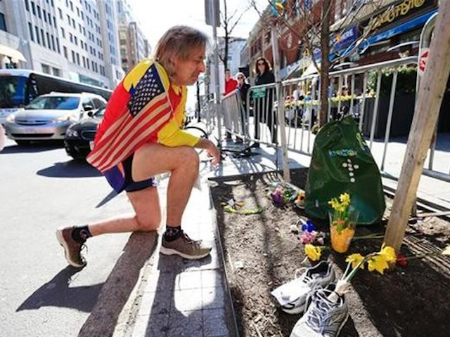 Ron McCracken of Dallas pays his respects at a makeshift memorial honoring to the victims of the 2013 Boston Marathon bombings ahead of Monday's 118th Boston Marathon, Sunday, April 20, 2014, in Boston. (AP Photo/Matt Rourke)